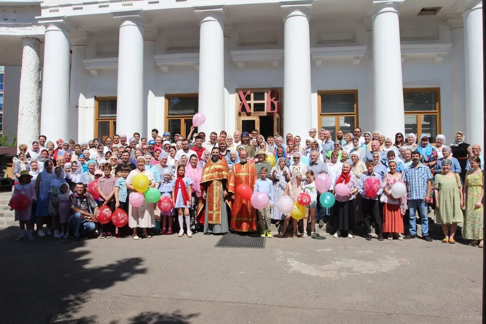 Большая группа прихожан на фоне колоннады Спасского храма, юбилейное торжество