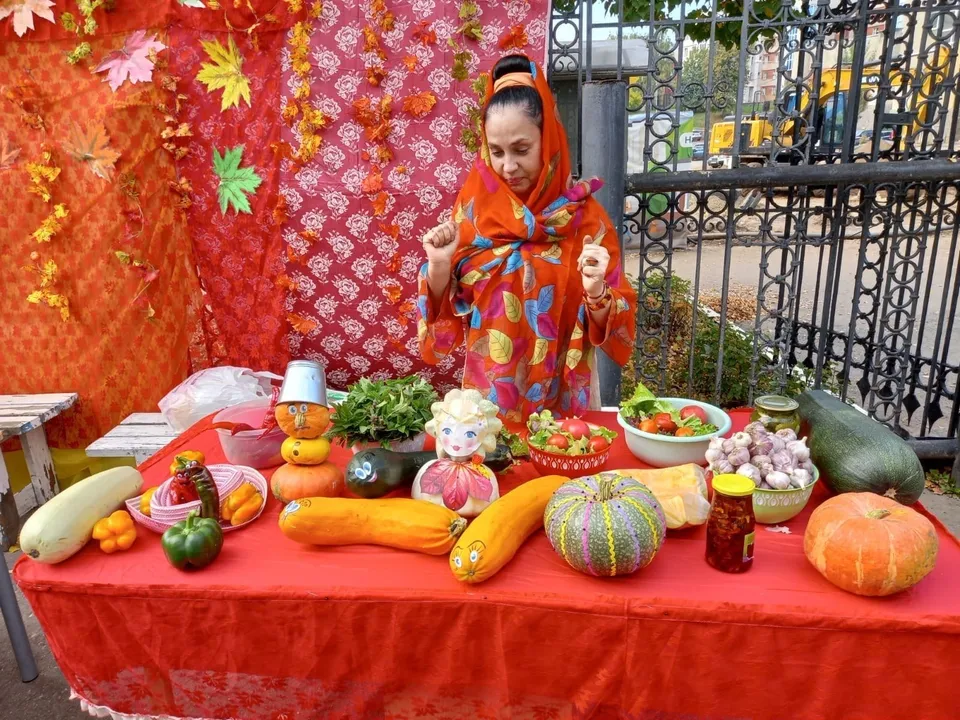 Прилавок благотворительной ярмарки «Дары осени», украшенный в осеннем стиле, с овощами и соленьями