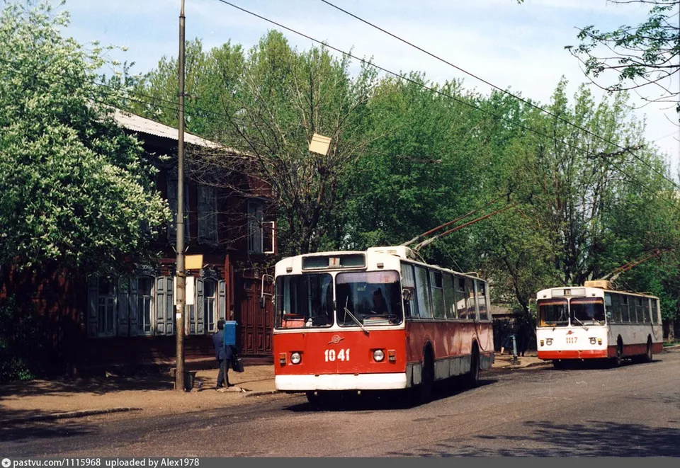 Два троллейбуса на улице у деревянного дома с резными наличниками, 1991 год